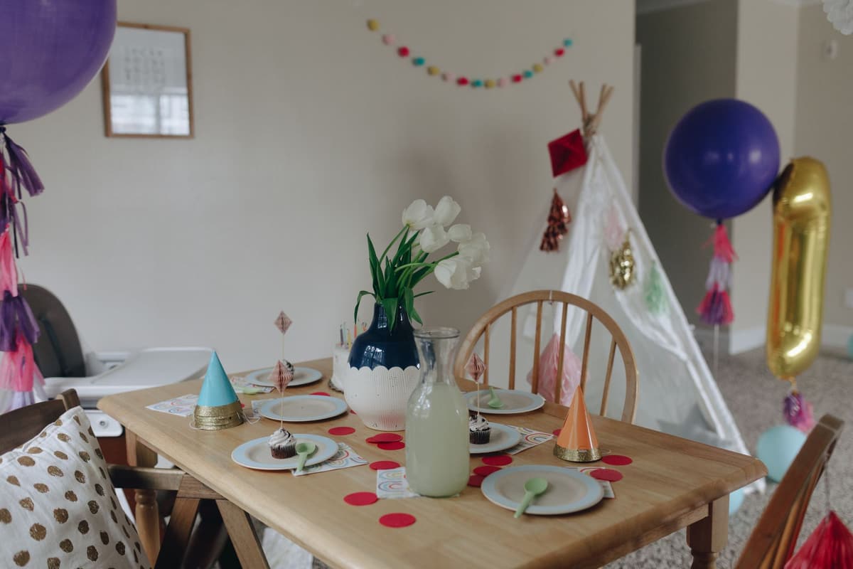Festive children's birthday party setup with balloons, cupcakes, and decorations indoors