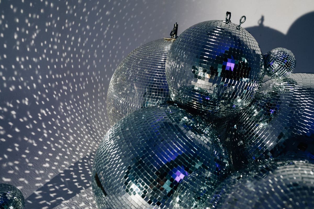 Cluster of disco balls casting shimmering reflections, embodying retro and festive vibes