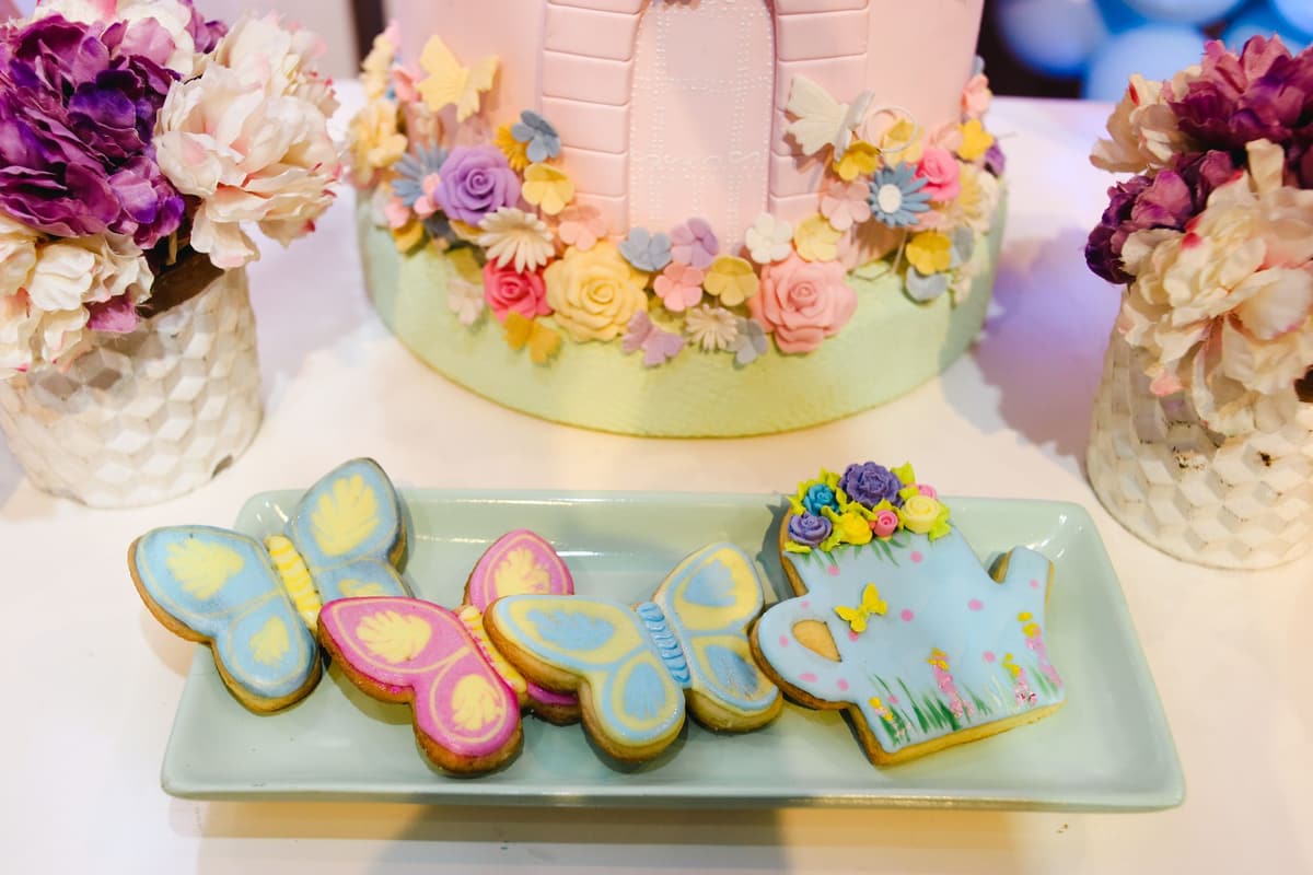 A vibrant display of butterfly-shaped cookies and floral cake, perfect for spring celebrations