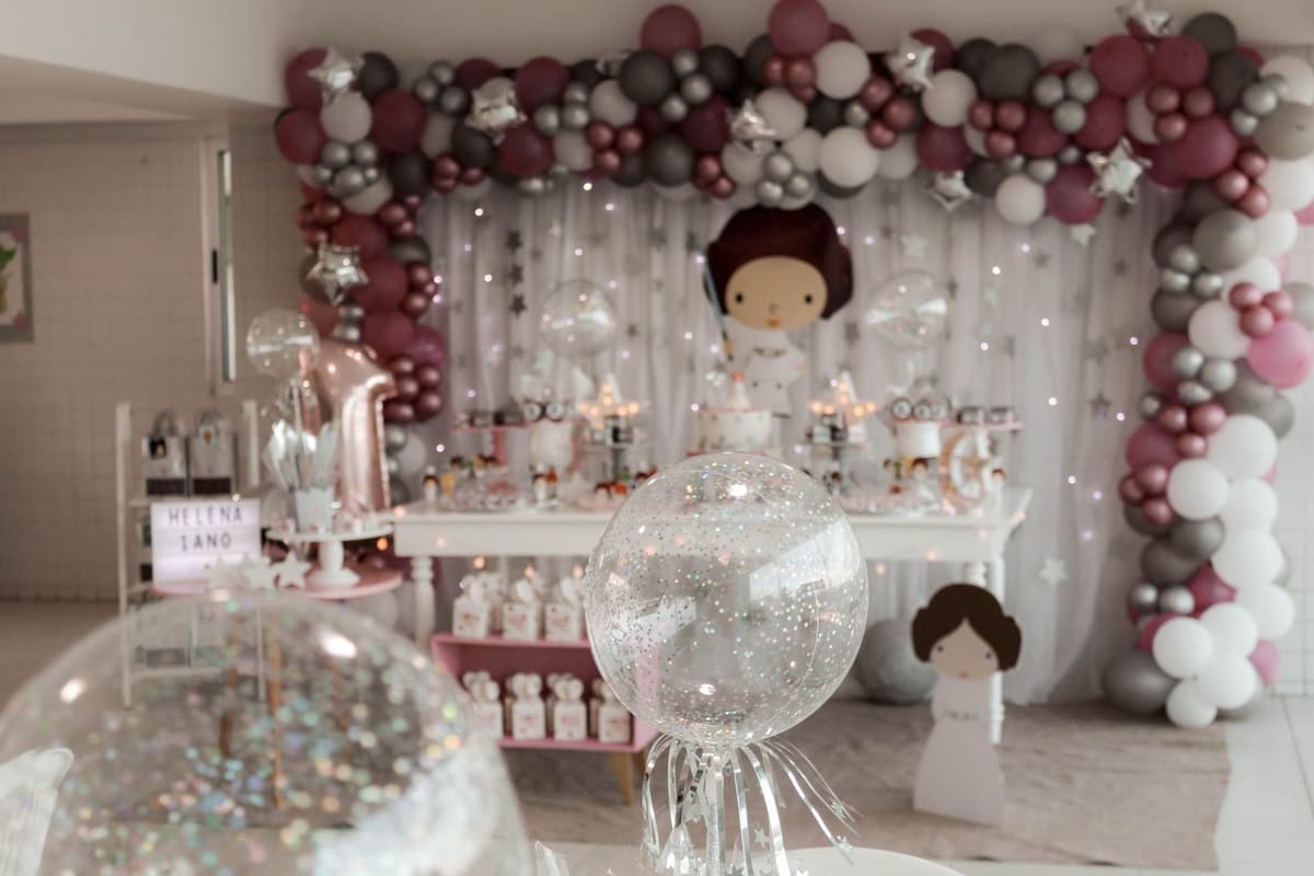 A magical indoor birthday party setup featuring balloons, fairy lights, and themed decorations