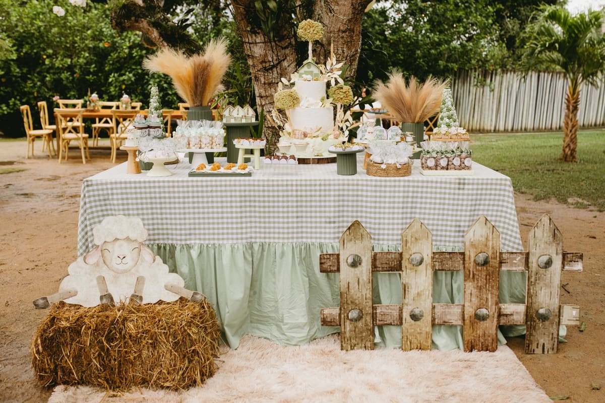 A charming outdoor farm-themed birthday table setting featuring cakes, sweets, and rustic decor