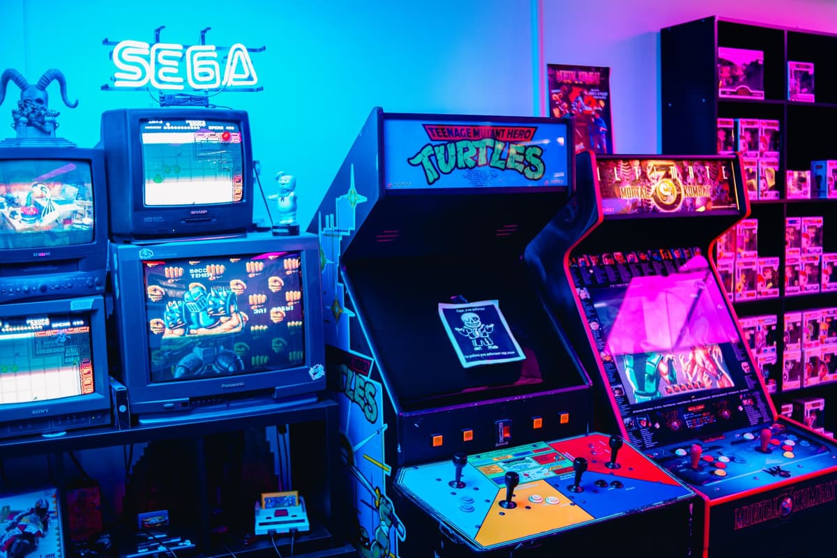A vibrant retro arcade room featuring classic gaming machines and colorful neon lighting