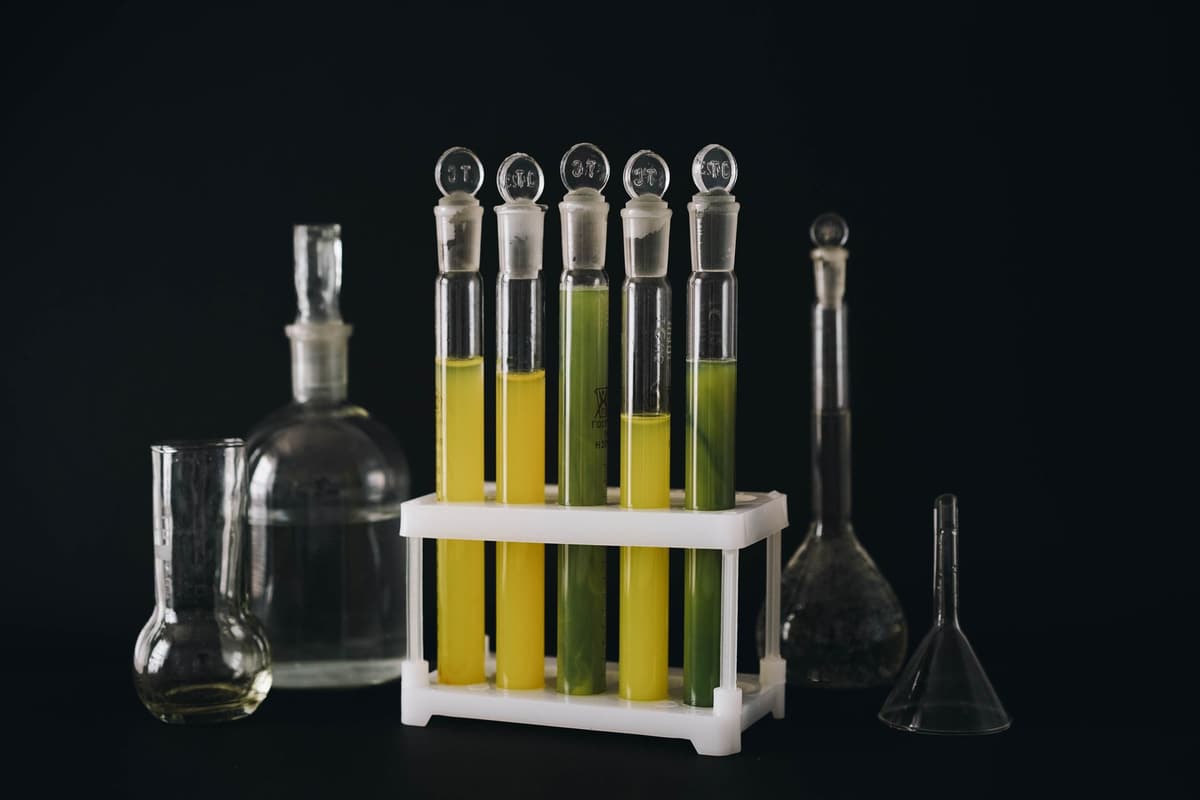 A collection of vibrant liquids in test tubes against a black background, showcasing chemistry equipment