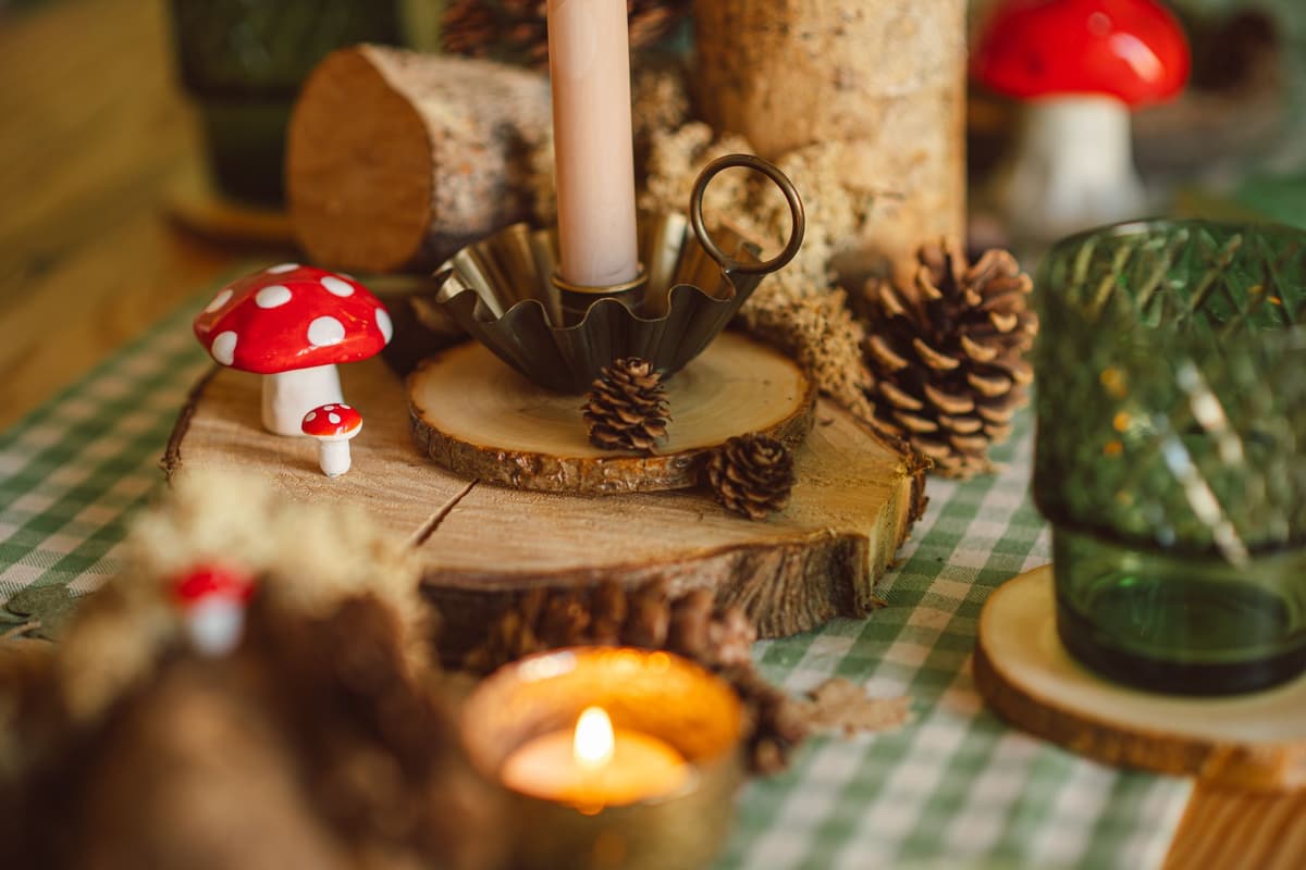 Charming woodland-themed table setting with pumpkins, pine cones, and candles perfect for autumn decor