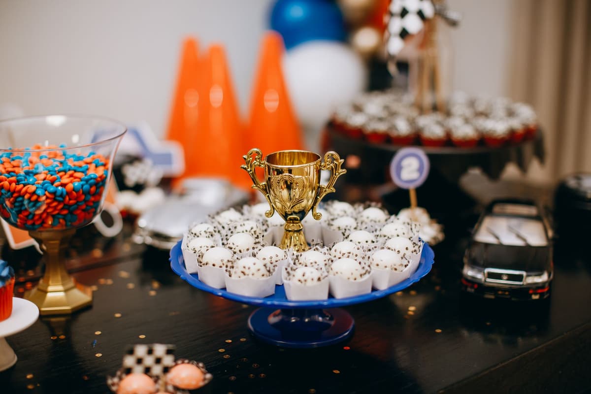 A colorful celebration setup featuring sweets and a trophy on a dessert table, perfect for parties and events