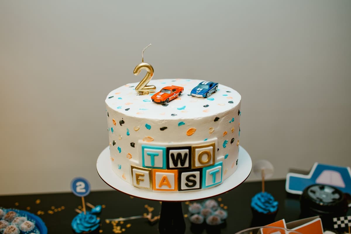 Vibrant birthday cake adorned with toy cars and colorful blocks, perfect for a 2-year-old's celebration