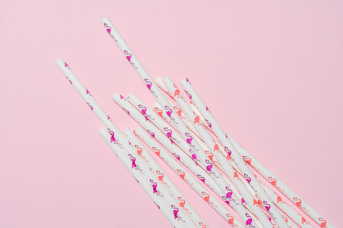 Colorful flamingo straws arranged on a pink pastel surface. Perfect for parties and celebrations