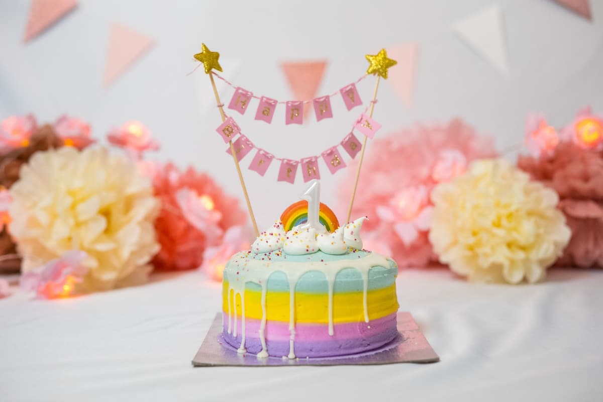 Vibrant rainbow cake with sprinkles and decorations for a birthday party