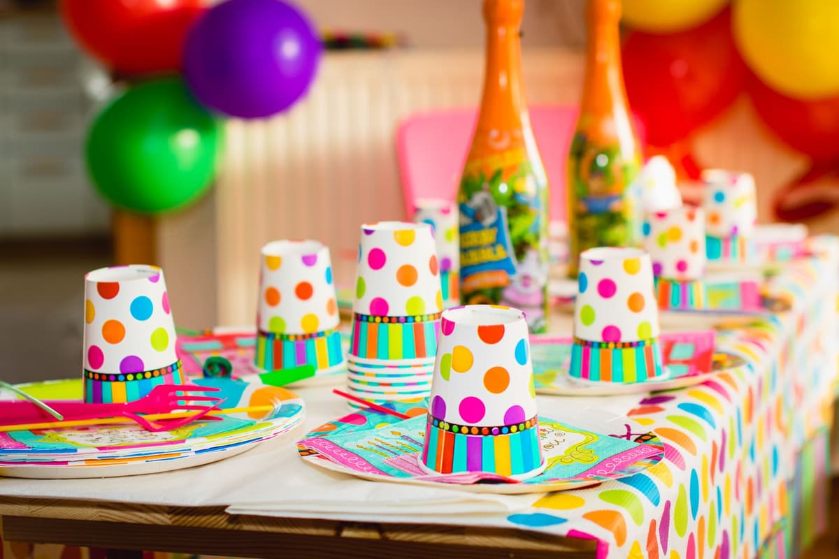 Colorful party table setup with polka dot cups and balloons, perfect for celebrations